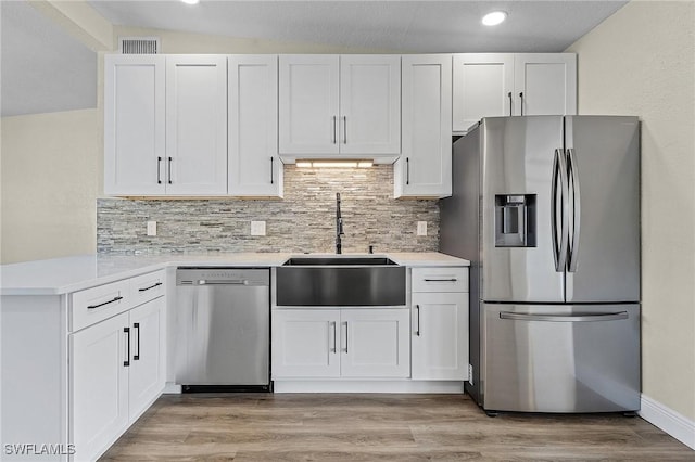 kitchen featuring sink, stainless steel appliances, kitchen peninsula, and white cabinets