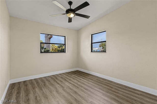 empty room featuring hardwood / wood-style floors, a healthy amount of sunlight, and ceiling fan