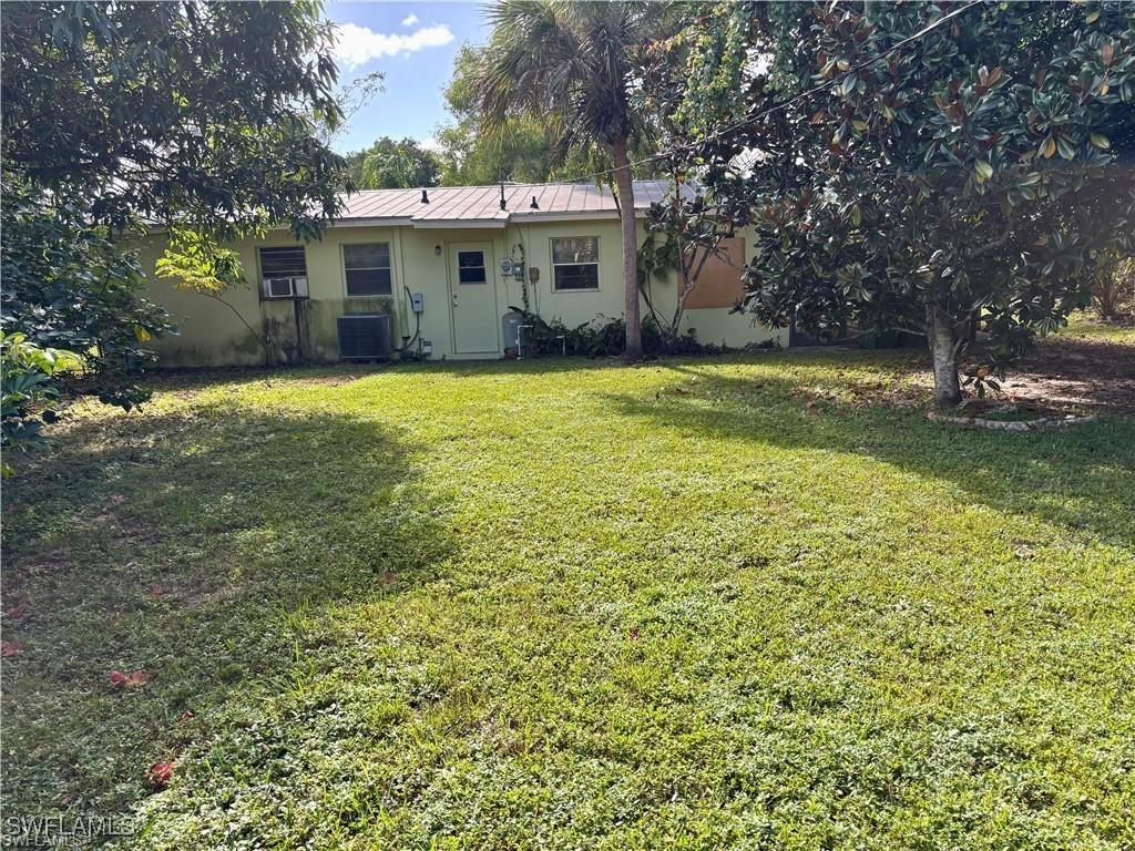 697 Pine Vale Dr, Naples, FL 34104 - view of yard with cooling unit and central AC unit