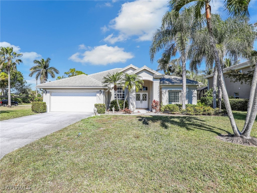 single story home featuring a garage and a front yard