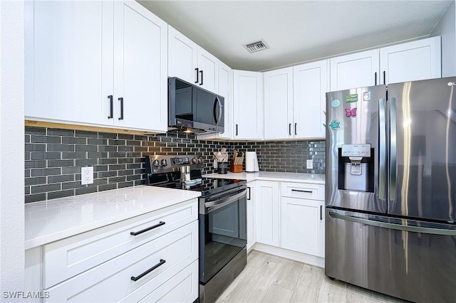 kitchen featuring visible vents, white cabinetry, and stainless steel appliances