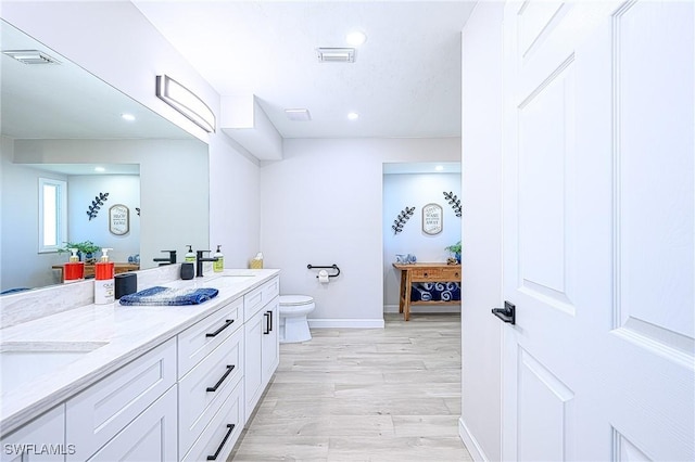 bathroom with vanity, hardwood / wood-style floors, and toilet