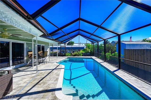 pool with a lanai, fence, and a patio