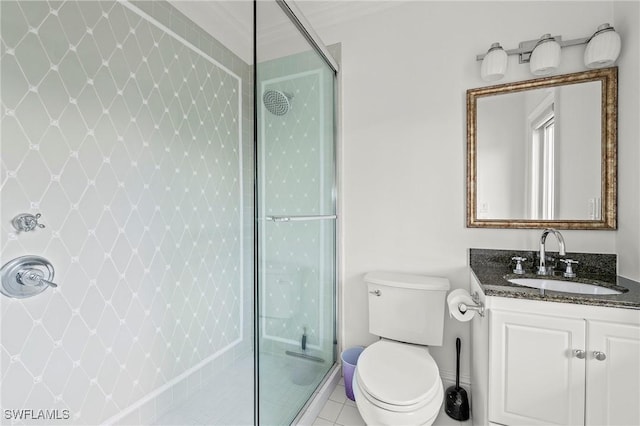 bathroom with vanity, toilet, tile patterned flooring, and a tile shower