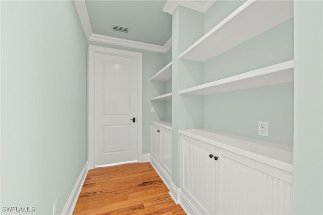 hallway featuring crown molding and light hardwood / wood-style floors