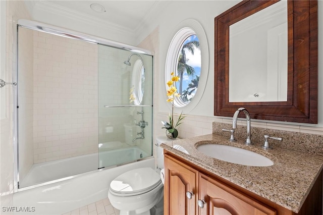 full bathroom featuring vanity, crown molding, shower / bath combination with glass door, and toilet