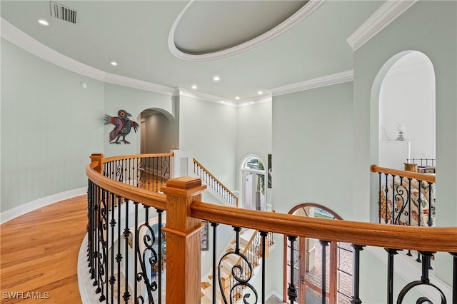 hall with ornamental molding and light hardwood / wood-style floors