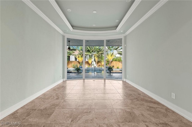 empty room featuring a raised ceiling and ornamental molding