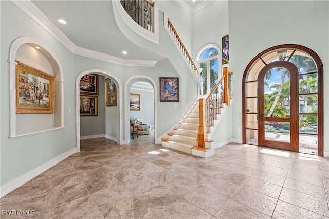 entrance foyer with crown molding, french doors, and a high ceiling