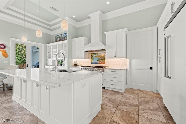 kitchen featuring premium range hood, sink, a center island with sink, light stone countertops, and white cabinets