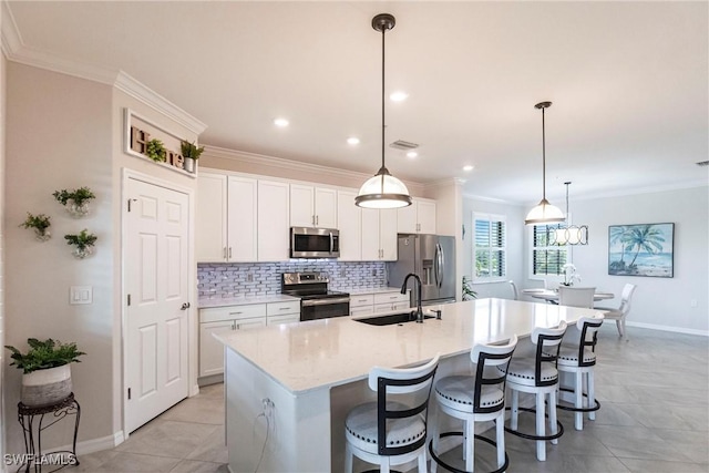 kitchen featuring sink, white cabinetry, decorative light fixtures, a center island with sink, and stainless steel appliances