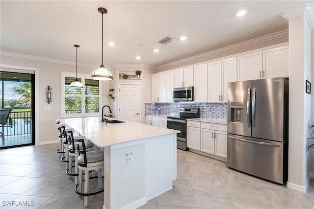 kitchen featuring stainless steel appliances, sink, an island with sink, and white cabinets