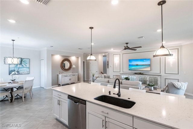 kitchen featuring sink, stainless steel dishwasher, white cabinets, and decorative light fixtures