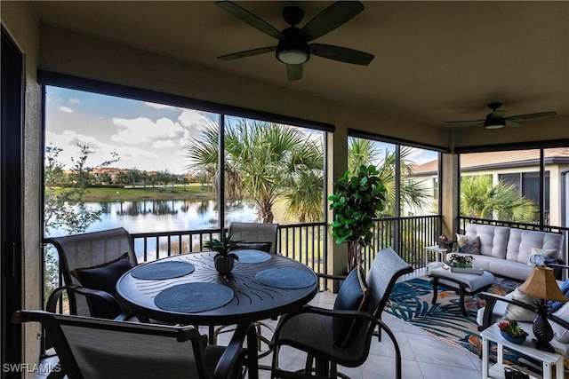 sunroom / solarium featuring ceiling fan and a water view