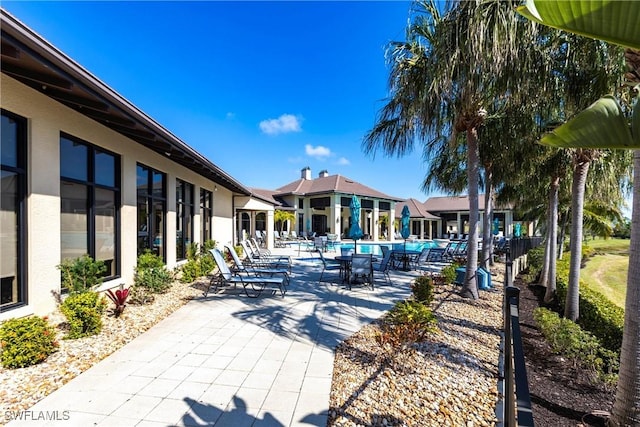 view of property's community featuring a swimming pool and a patio