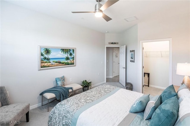 bedroom featuring light carpet, a spacious closet, a closet, and ceiling fan