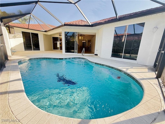 view of swimming pool with a lanai, ceiling fan, and a patio area