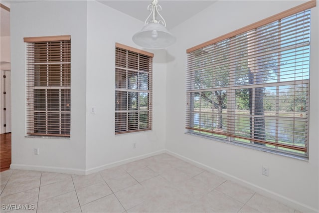 unfurnished room with light tile patterned floors and a healthy amount of sunlight