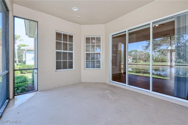 unfurnished sunroom with a water view and a wealth of natural light