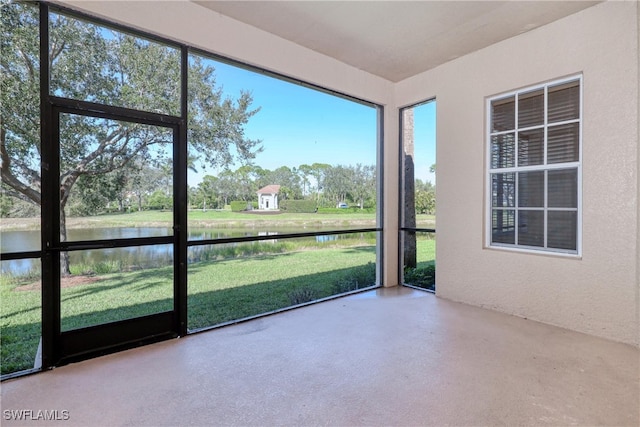 unfurnished sunroom featuring a water view