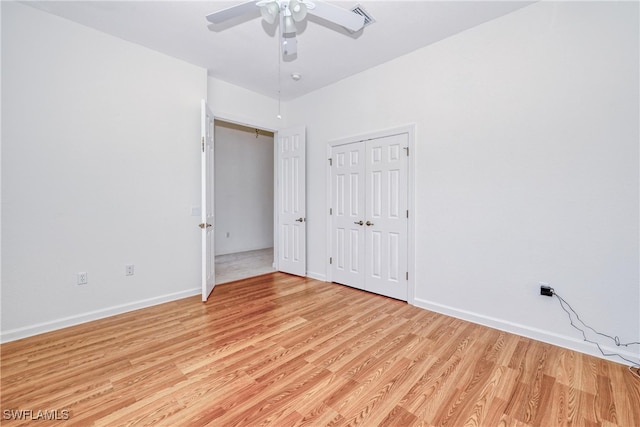 unfurnished bedroom featuring ceiling fan, a closet, and light wood-type flooring