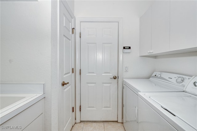 washroom featuring cabinets, separate washer and dryer, and light tile patterned floors