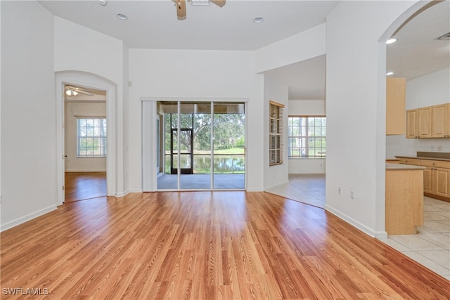 unfurnished living room with ceiling fan and light hardwood / wood-style flooring