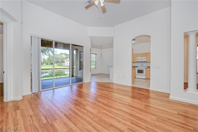 unfurnished living room featuring decorative columns, light hardwood / wood-style floors, and ceiling fan