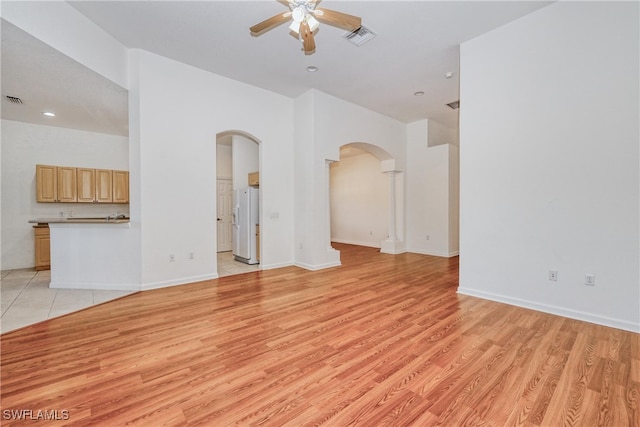 unfurnished living room featuring ceiling fan and light wood-type flooring