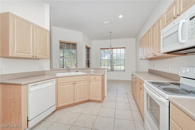 kitchen featuring a wealth of natural light, sink, hanging light fixtures, light brown cabinets, and white appliances