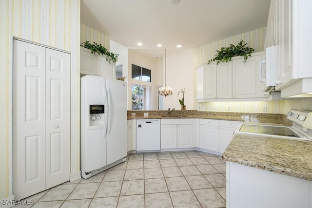 1575 Clermont Dr Unit N-201, Naples, FL 34109 - kitchen with white appliances, a chandelier, white cabinets, light tile patterned floors, and recessed lighting