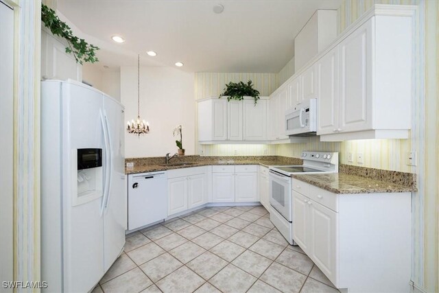 1575 Clermont Dr Unit N-201, Naples, FL 34109 - kitchen featuring white appliances, a chandelier, white cabinets, stone counters, and recessed lighting