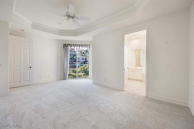 1575 Clermont Dr Unit N-201, Naples, FL 34109 - unfurnished bedroom with crown molding, a tray ceiling, carpet flooring, ensuite bath, and ceiling fan