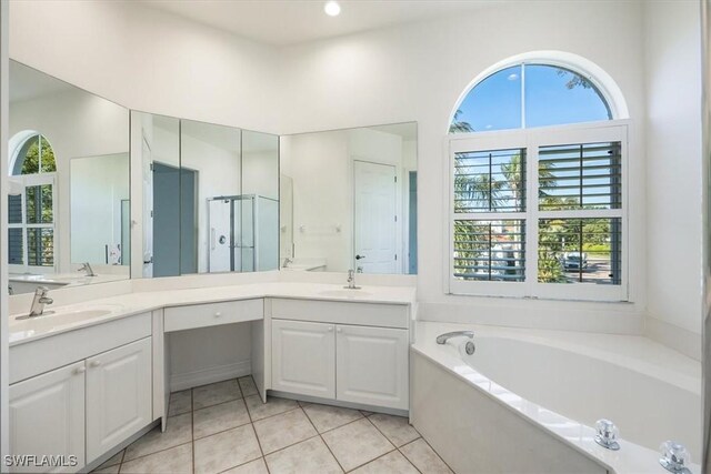 1575 Clermont Dr Unit N-201, Naples, FL 34109 - bathroom featuring plenty of natural light, a bath, double vanity, and tile patterned flooring