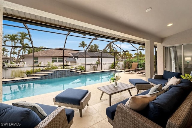 view of swimming pool with an outdoor living space, a patio, and a lanai