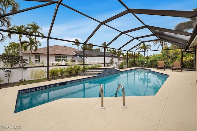 view of pool with glass enclosure and a patio area