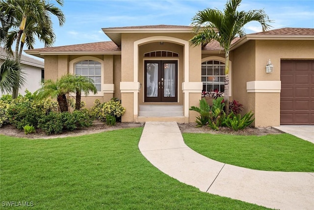 property entrance with french doors, a garage, and a yard