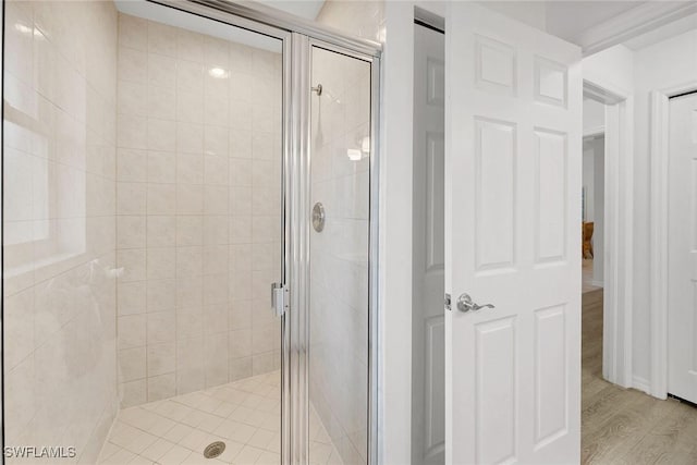 bathroom with hardwood / wood-style flooring and an enclosed shower