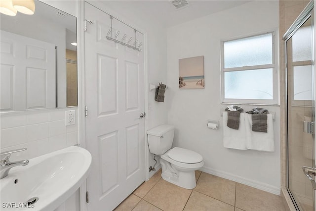 bathroom featuring sink, tile patterned flooring, an enclosed shower, and toilet