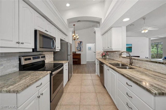 kitchen featuring appliances with stainless steel finishes, white cabinetry, and light stone counters