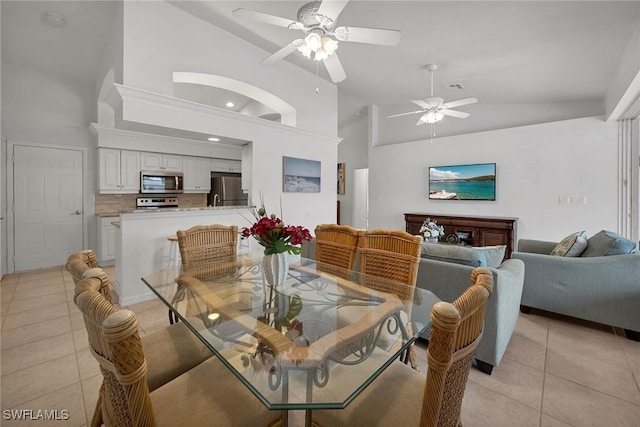 dining room featuring high vaulted ceiling, ceiling fan, and light tile patterned floors