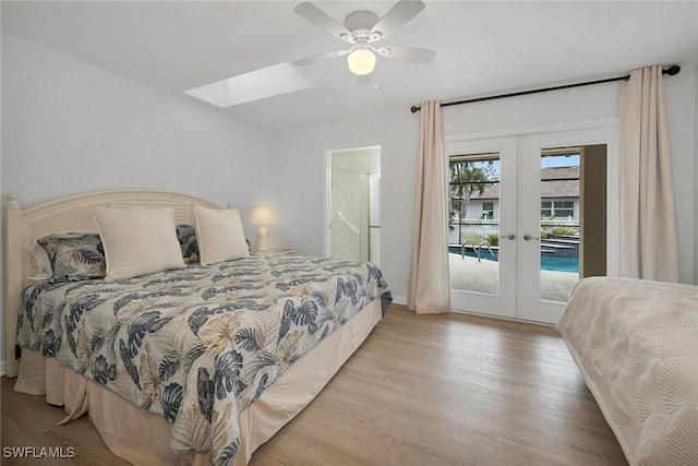 bedroom with light wood-type flooring, french doors, access to exterior, ceiling fan, and a skylight