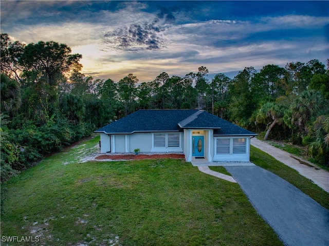 ranch-style home with a yard