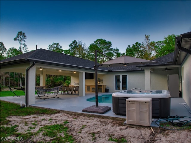 rear view of house with a patio area, a hot tub, and ceiling fan