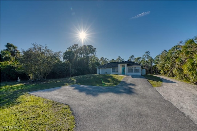 single story home with a garage and a front lawn