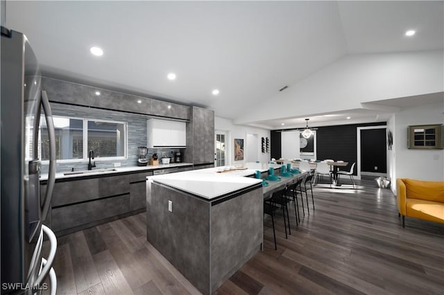 kitchen featuring dark hardwood / wood-style flooring, sink, stainless steel fridge, and a center island