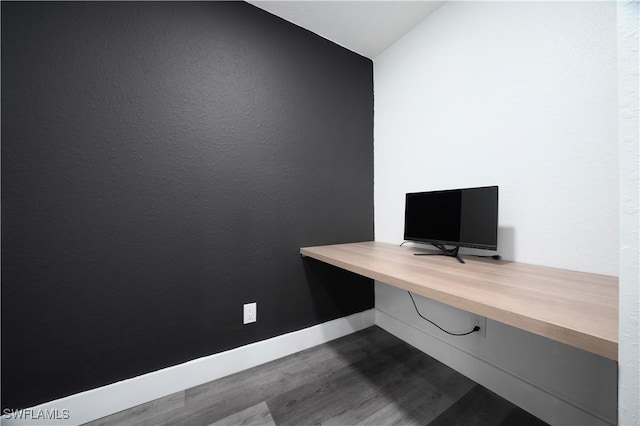 unfurnished office featuring hardwood / wood-style flooring and built in desk