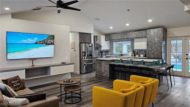 living room with hardwood / wood-style flooring, high vaulted ceiling, french doors, and ceiling fan