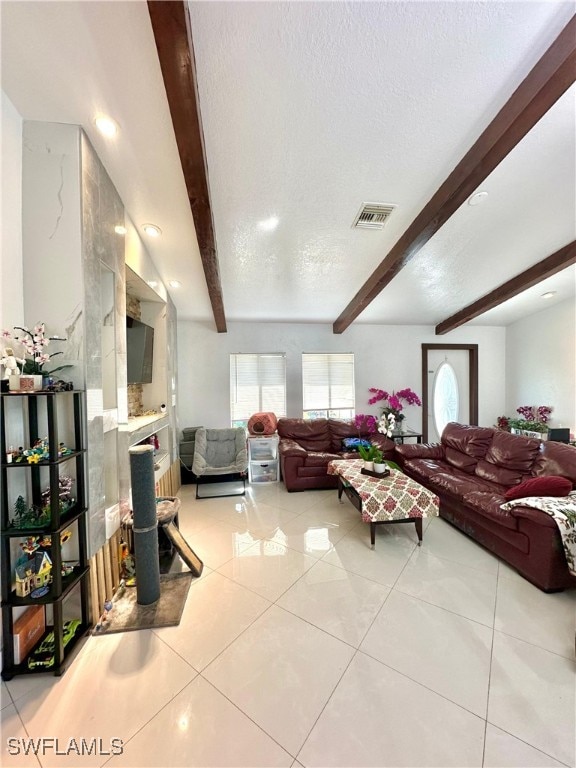 tiled living room with a textured ceiling and beamed ceiling