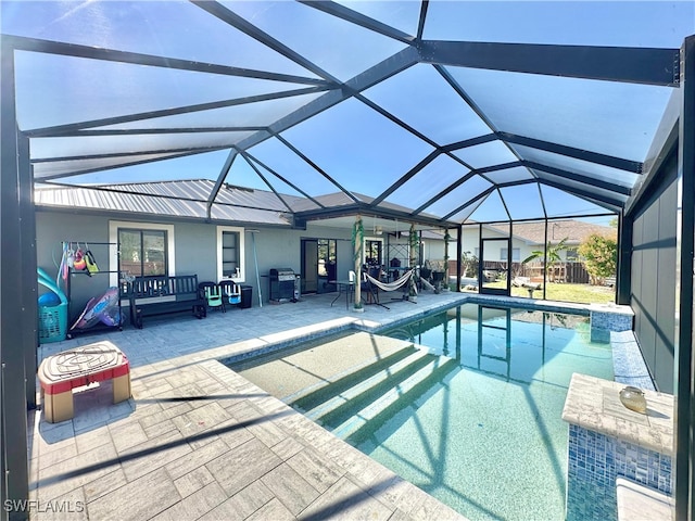 view of pool with a grill, a patio area, and glass enclosure